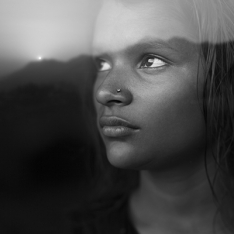 Image of woman looking out window at sunset