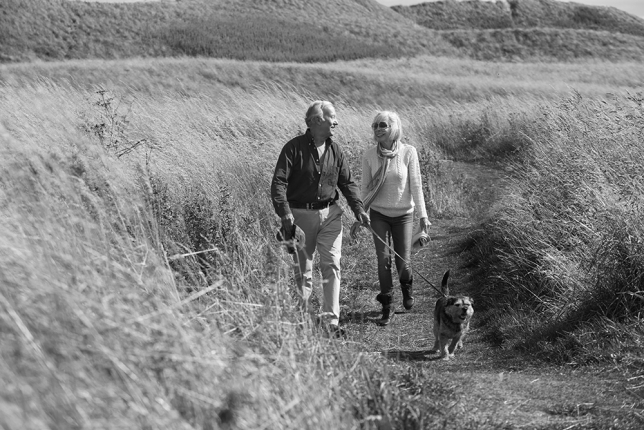 Senior couple walking with their dog in the countryside